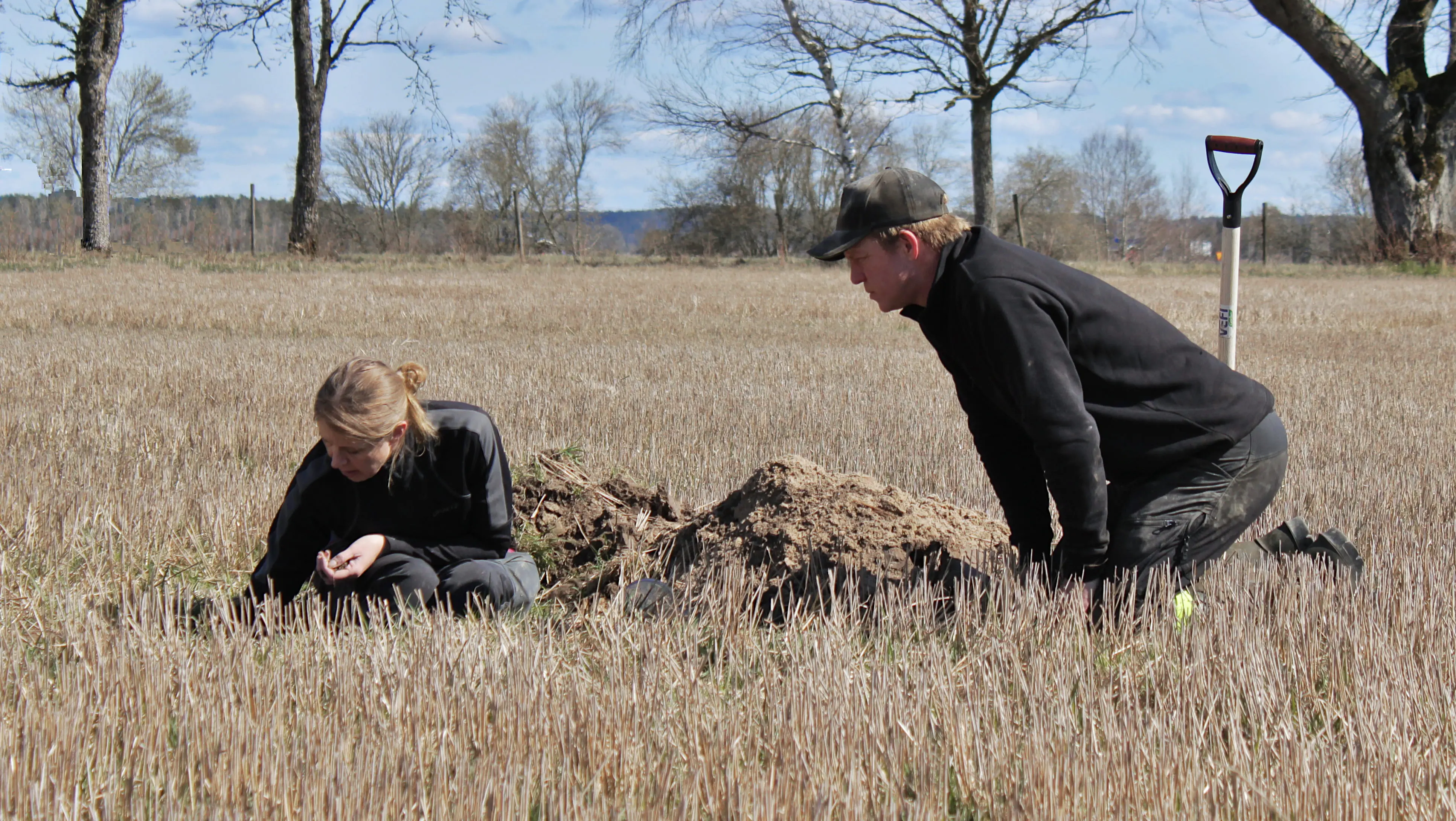 Rådgivare och lantbrukare gräver en grop